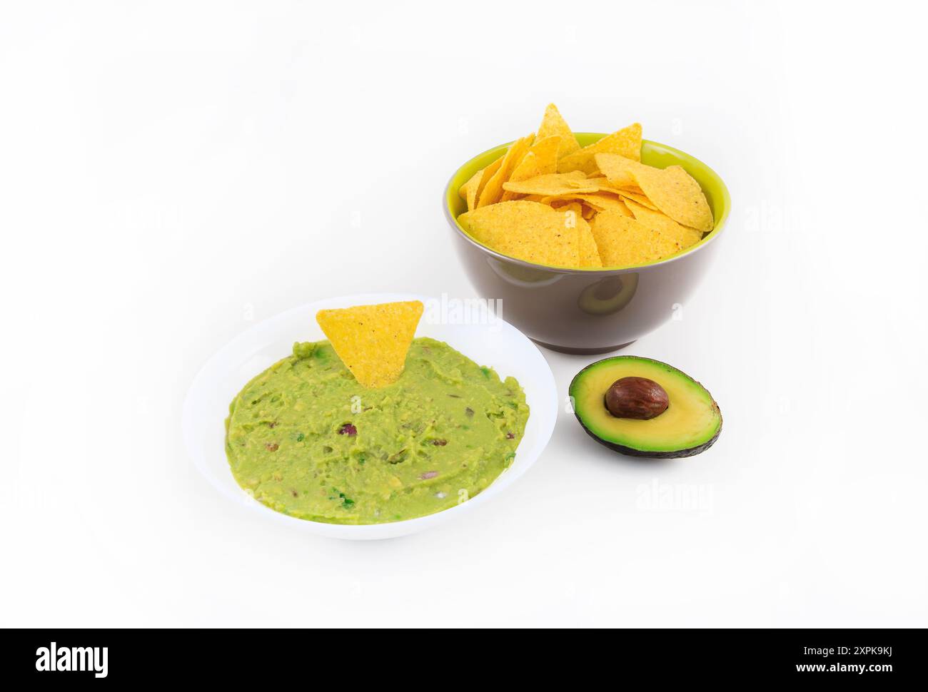 Bol de guacamole et nachos sur fond blanc. Banque D'Images