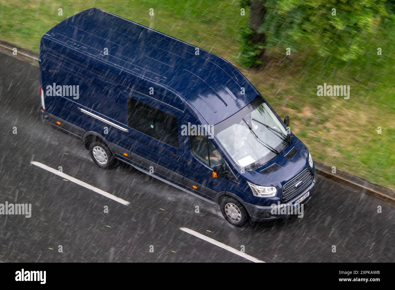 OSTRAVA, RÉPUBLIQUE TCHÈQUE - 25 MAI 2024 : fourgon de panneau Ford transit Mk4 conduisant sur route mouillée, forte pluie avec effet de flou de mouvement Banque D'Images