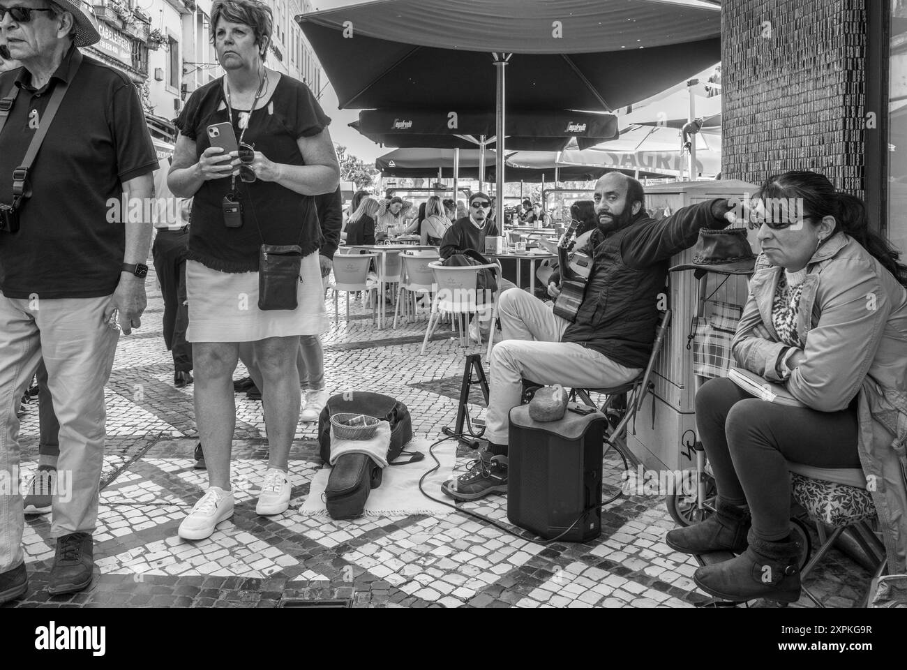 Musicien de rue prenant une pause de jouer de la guitare sur la rue piétonne Ferreira Borges dans la ville portugaise de Coimbra, Portugal, Europe Banque D'Images