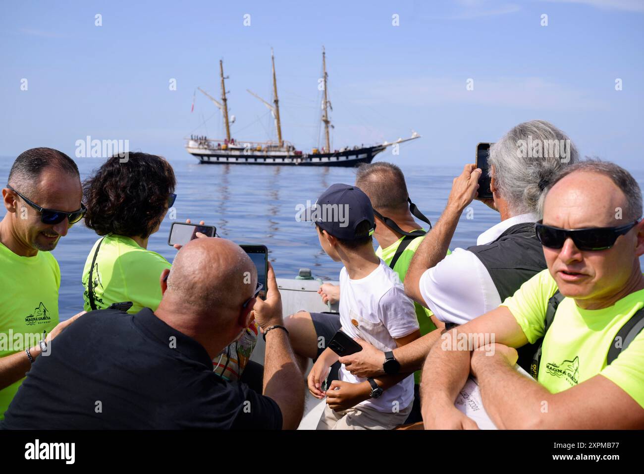 Scilla, Italie. 06 août 2024. Des membres de l'Association Magna Grecia et d'autres ont vu regarder un navire d'entraînement Palinuro. Une cérémonie pour le capitaine natale de Grazia de la frégate de la marine italienne, décédé mystérieusement en 1995, a eu lieu à bord du navire d'entraînement Palinuro de la marine italienne à Scilla, en Italie. Grâce aux efforts de Magna Grecia Outdoor Association et de la section Scilla de l'Association des marins italiens, le port de Scilla sera dédié à de Grazia. (Photo de Valeria Ferraro/SOPA images/SIPA USA) crédit : SIPA USA/Alamy Live News Banque D'Images