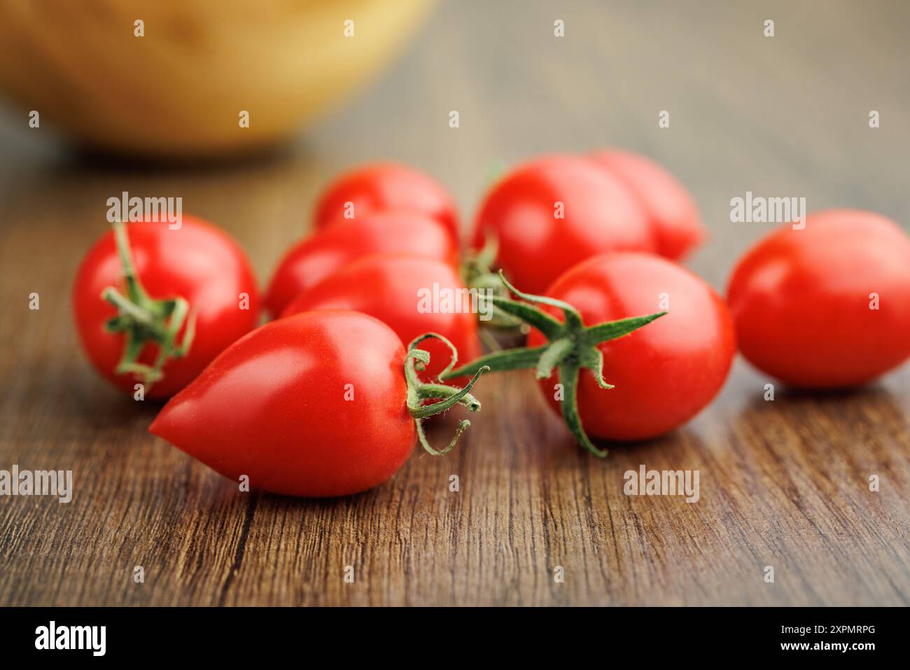 Tomates cerises rouges sur une table en bois. Banque D'Images