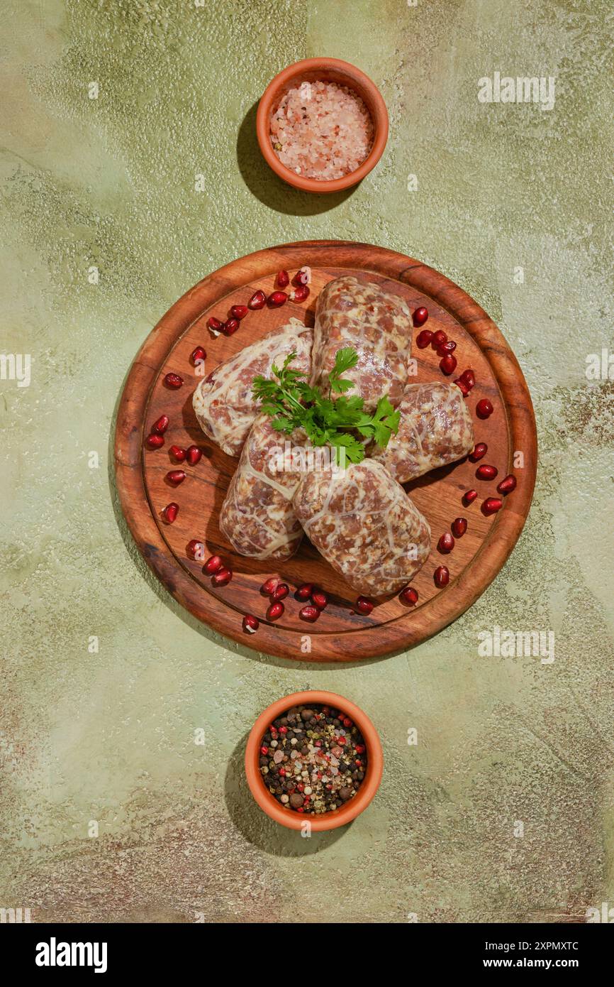 Vue aérienne de côtelettes de bœuf cru géorgien ou d'agneau - Apkhazura avec épices et herbes sur une planche à découper en bois Banque D'Images