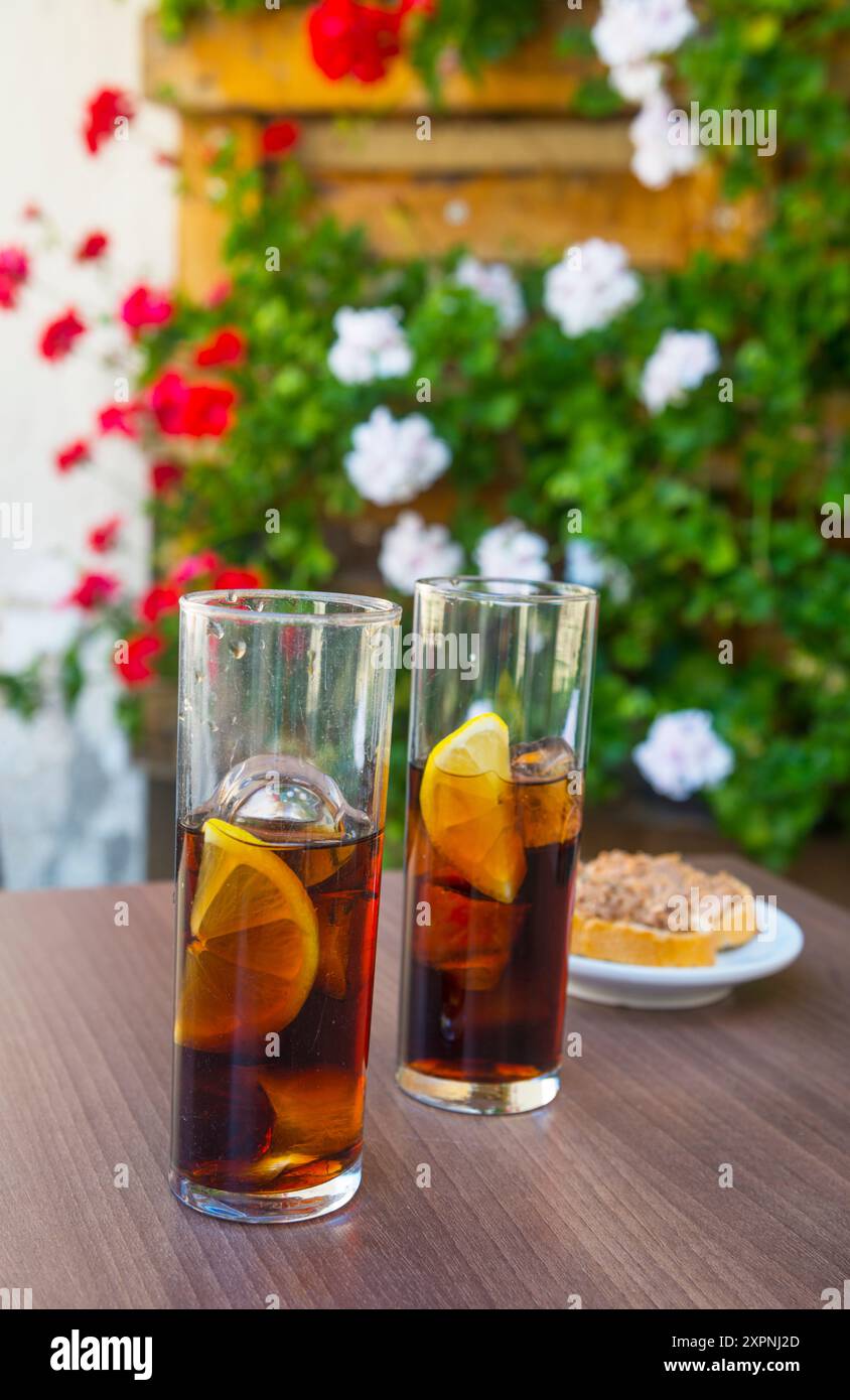 Deux verres de vermouth avec tapa sur une terrasse. Espagne. Banque D'Images