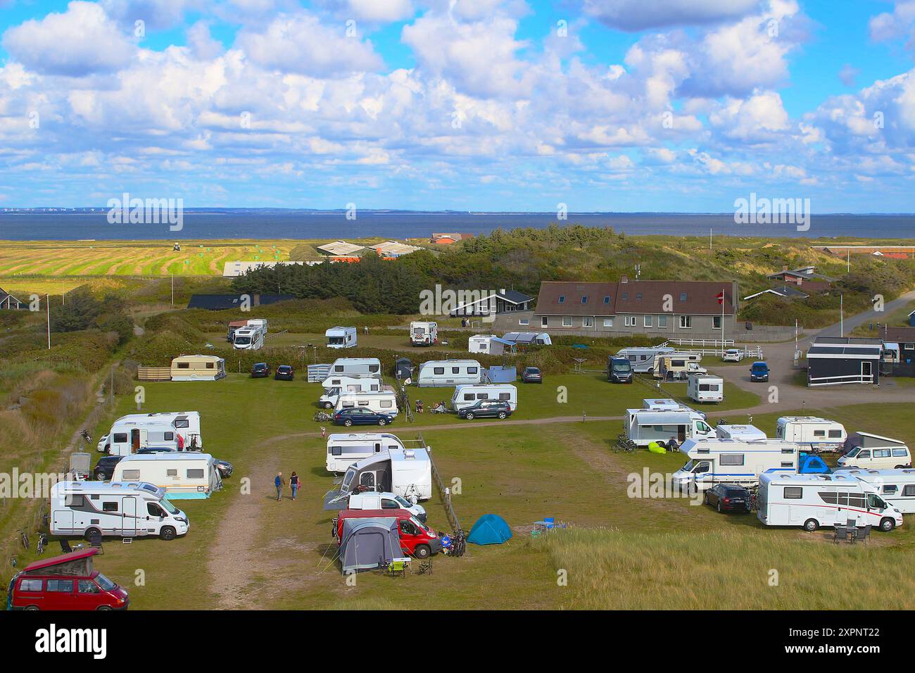 Vue sur les camping-cars et caravanes sur le site de camping au milieu des dunes jusqu'au fjord Ringkobing à l'horizon (Hvide Sande, Danemark) Banque D'Images