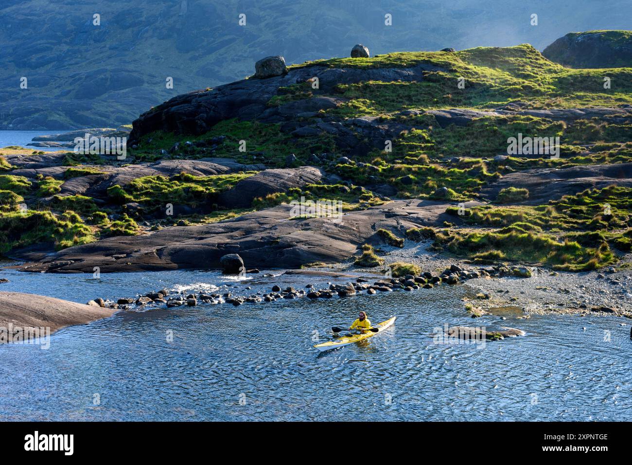 Un kayakiste sur le Loch Coruisk près des tremplins sur la rivière Scavaig. Dans les montagnes Cuillin, île de Skye, Écosse, Royaume-Uni. Banque D'Images