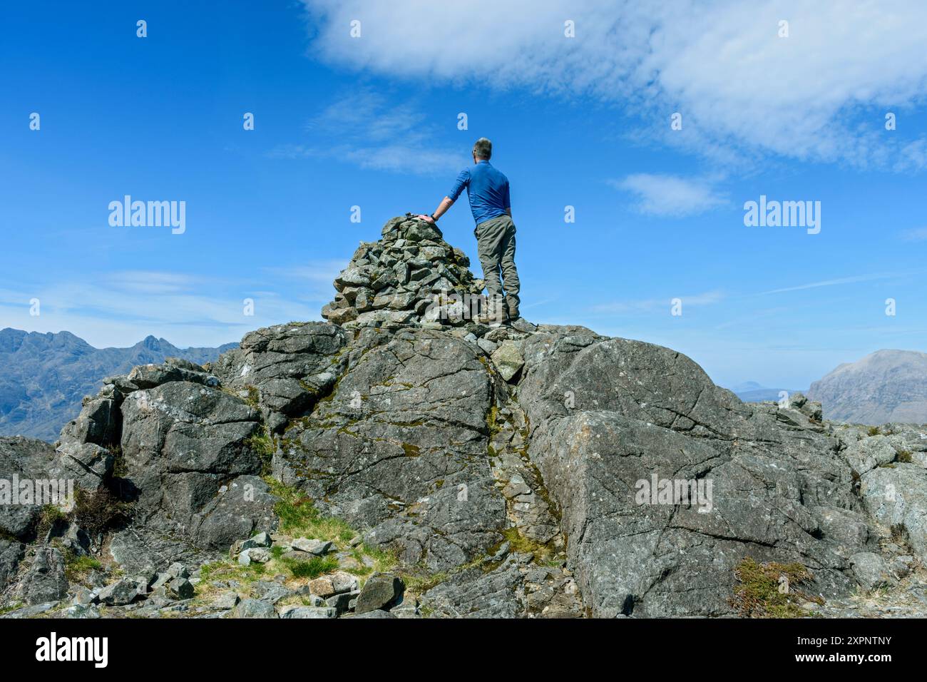 Un marcheur sur les rochers sommitaux de Sgùrr na STRI, dans les montagnes Cuillin, île de Skye, Écosse, Royaume-Uni. Banque D'Images