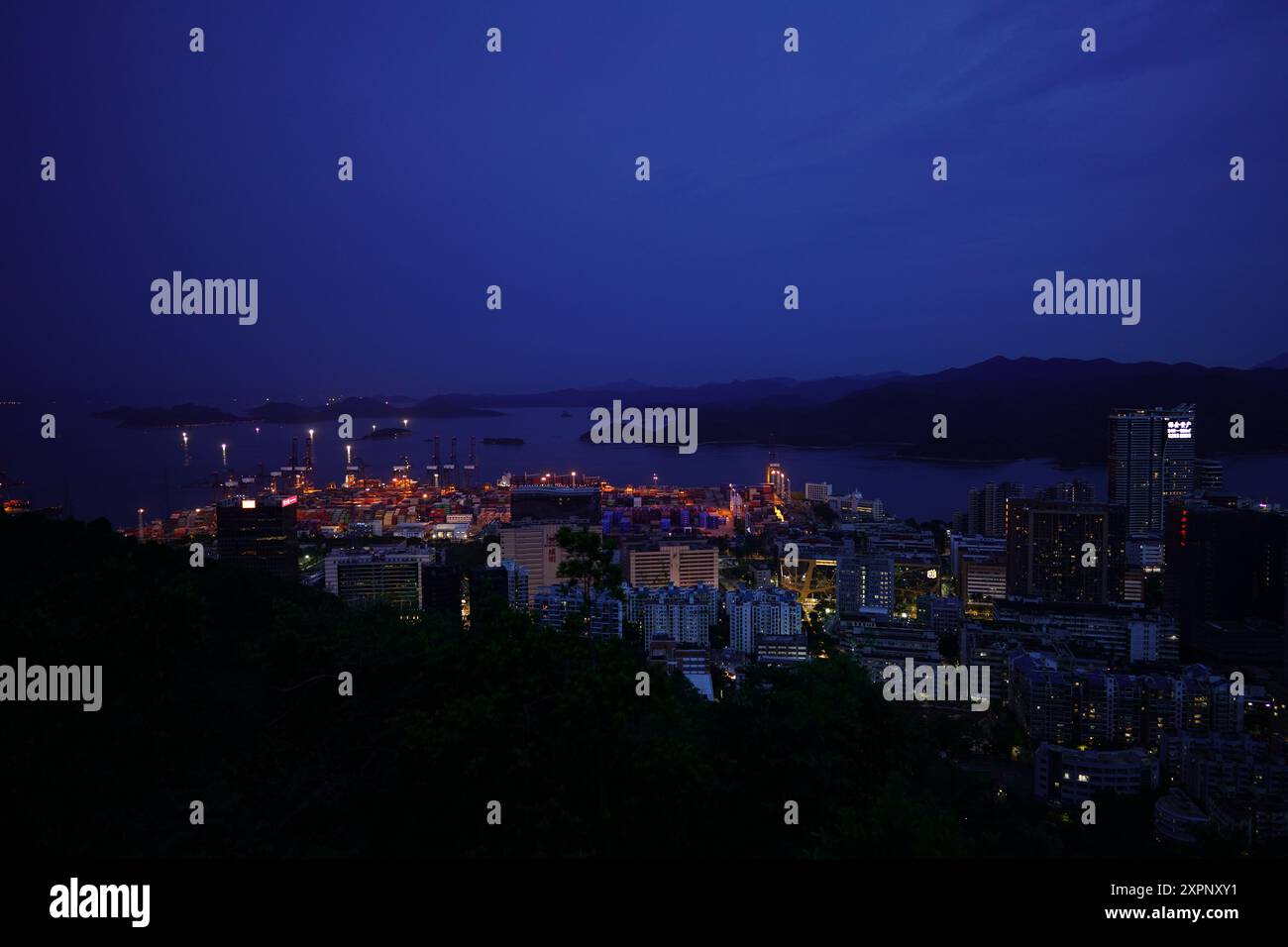 Vue imprenable de nuit sur les gratte-ciel illuminés de Sha Tau Kok depuis Wutong Hill, mettant en valeur le paysage urbain pittoresque de la ville frontalière sous un ciel étoilé. Banque D'Images