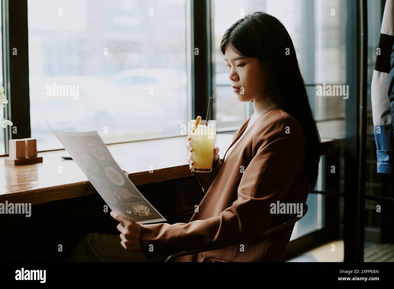 Lire le menu tout en sirotant de la limonade dans Cozy Cafe Banque D'Images