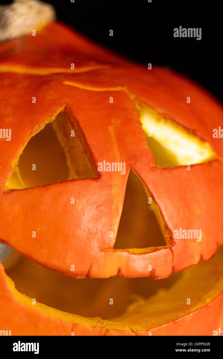 Citrouille d'Halloween luisante jack-o-lanterne sur un fond noir. Soldes d'Halloween. Banque D'Images