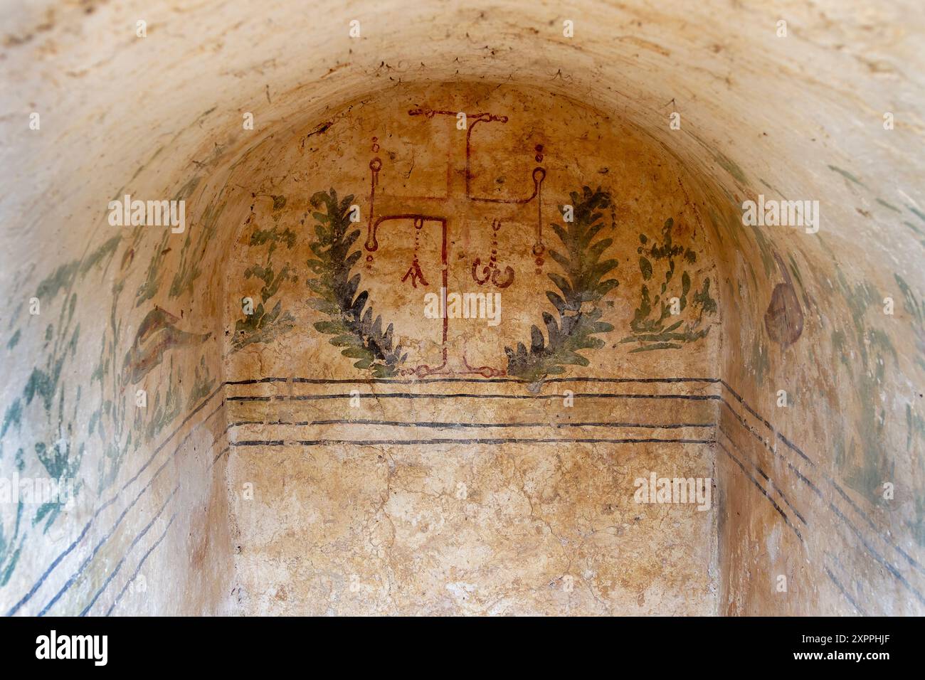 Fresque byzantine d'une croix entourée de branches d'oliviers dans un ancien tombeau chrétien, mettant en valeur le symbolisme religieux et l'art historique Banque D'Images