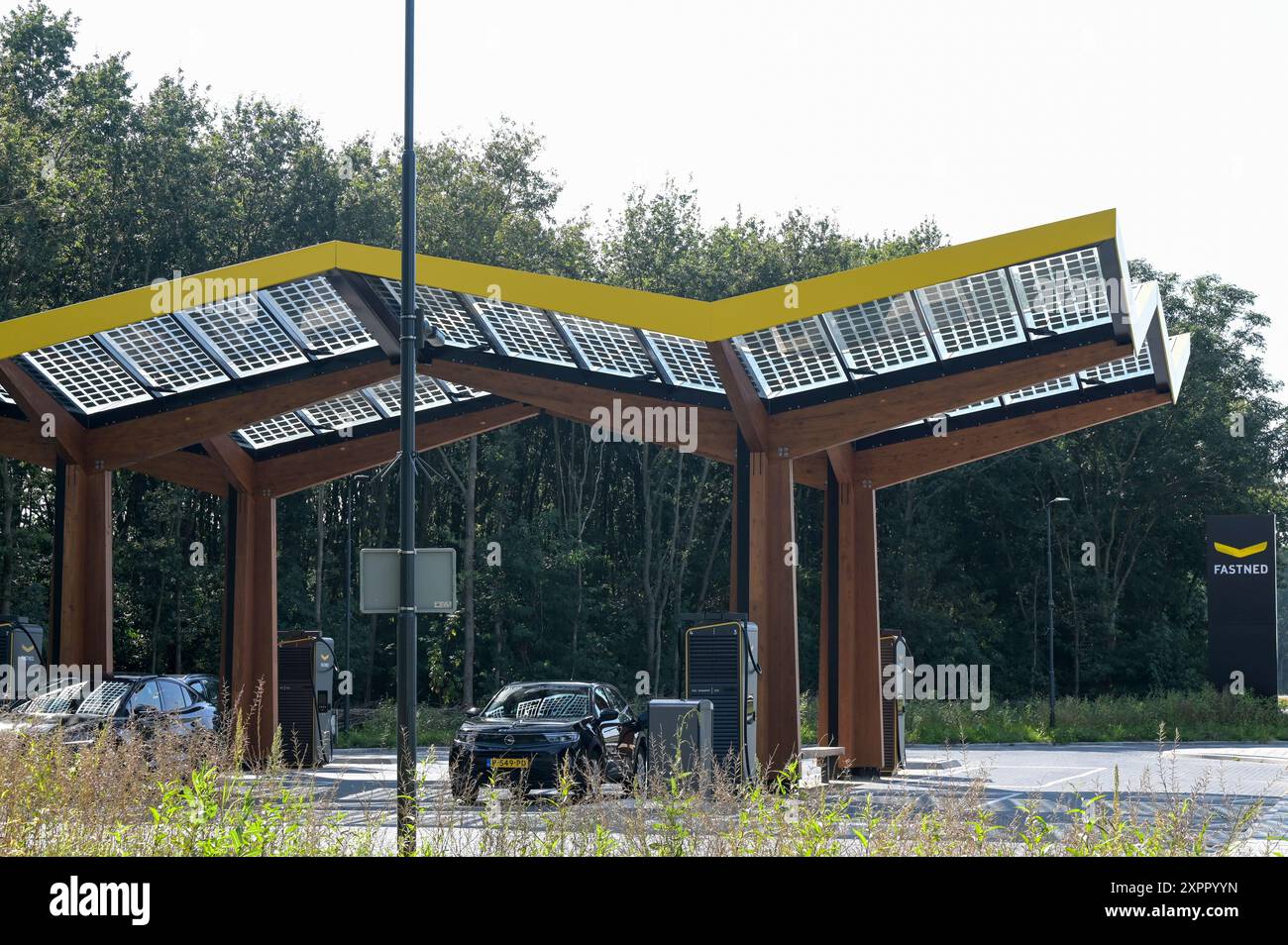 PAYS-BAS, Fastned station de recharge rapide pour véhicule électrique à la station-service sur autoroute, cellules solaires sur toit / NIEDERLANDE, Fastned Stromladestation für Elektrofahrzeuge an Tankstelle an der Autobahn, Solarzellen auf Dach, Opel Mokka Banque D'Images