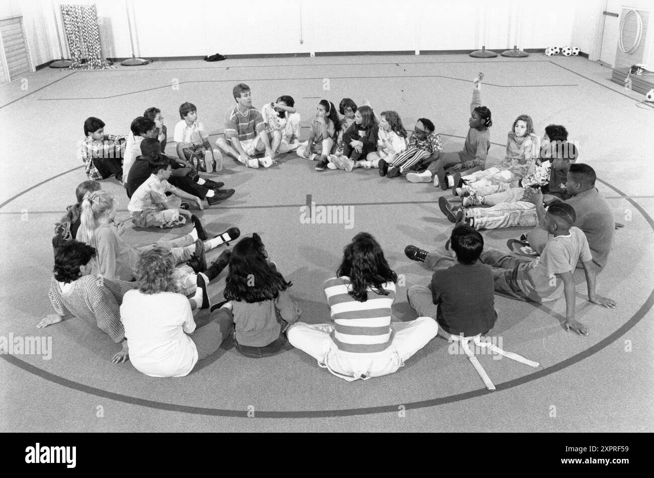 Austin Texas USA, 1991 : un professeur d'éducation physique masculine discute pendant la classe de P.E. dans le gymnase scolaire à l'école primaire Walnut Creek. Dossier EH-0206 ©Bob Daemmrich Banque D'Images Austin Texas USA, 1991 : un professeur d'éducation physique masculine discute pendant la classe de P.E. dans le gymnase scolaire à l'école primaire Walnut Creek. Dossier EH-0206 ©Bob Daemmrich Banque D'Images