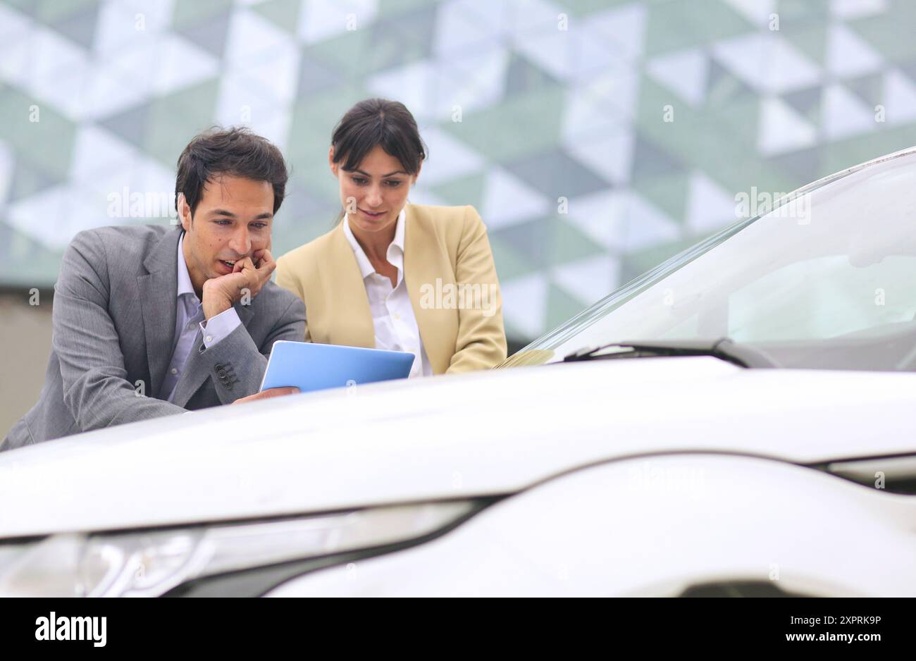 Businessman and businesswoman with tablet dans parking centre d'affaires. Parc Technologique de San Sebastian. Donostia. Gipuzkoa. Pays Basque. L'Espagne. Banque D'Images