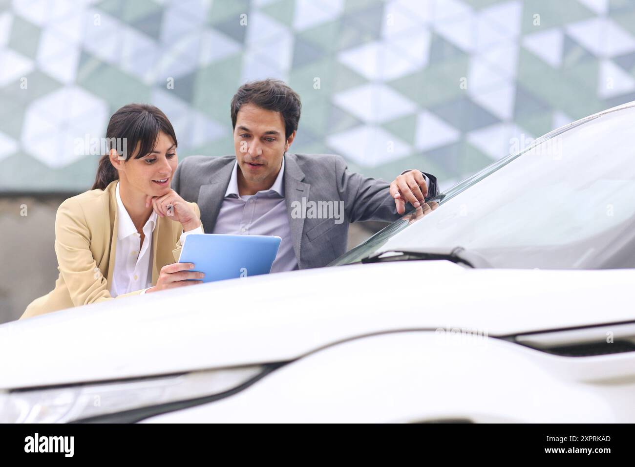 Businessman and businesswoman with tablet dans parking centre d'affaires. Parc Technologique de San Sebastian. Donostia. Gipuzkoa. Pays Basque. L'Espagne. Banque D'Images