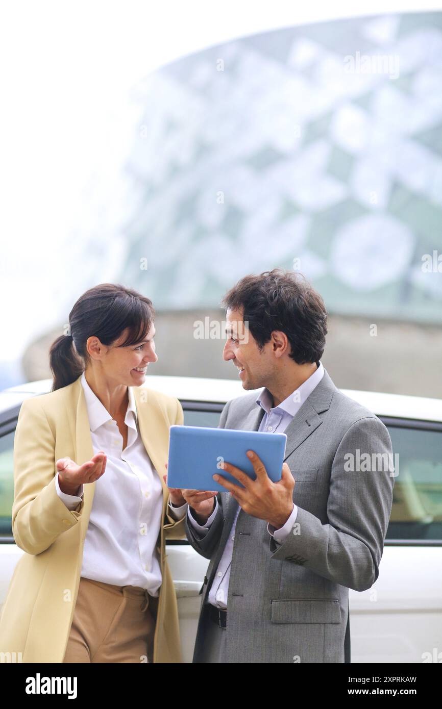 Business man and woman with tablet dans parking centre d'affaires. Parc Technologique de San Sebastian. Donostia. Gipuzkoa. Pays Basque. L'Espagne. Banque D'Images