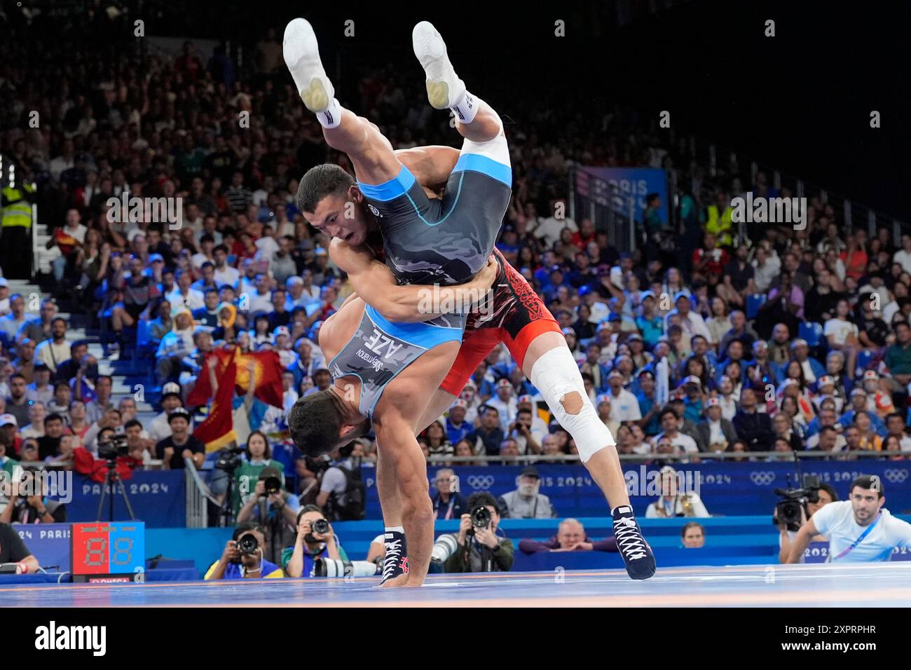 Kyrgyzstan's Akzhol Makhmudov, top, and Azerbaijan's Sanan Suleymanov compete during their men's Greco-Roman 77kg bronze medal wrestling match, at Champ-de-Mars Arena, during the 2024 Summer Olympics, Wednesday, Aug. 7, 2024, in Paris, France. (AP Photo/Eugene Hoshiko) Banque D'Images