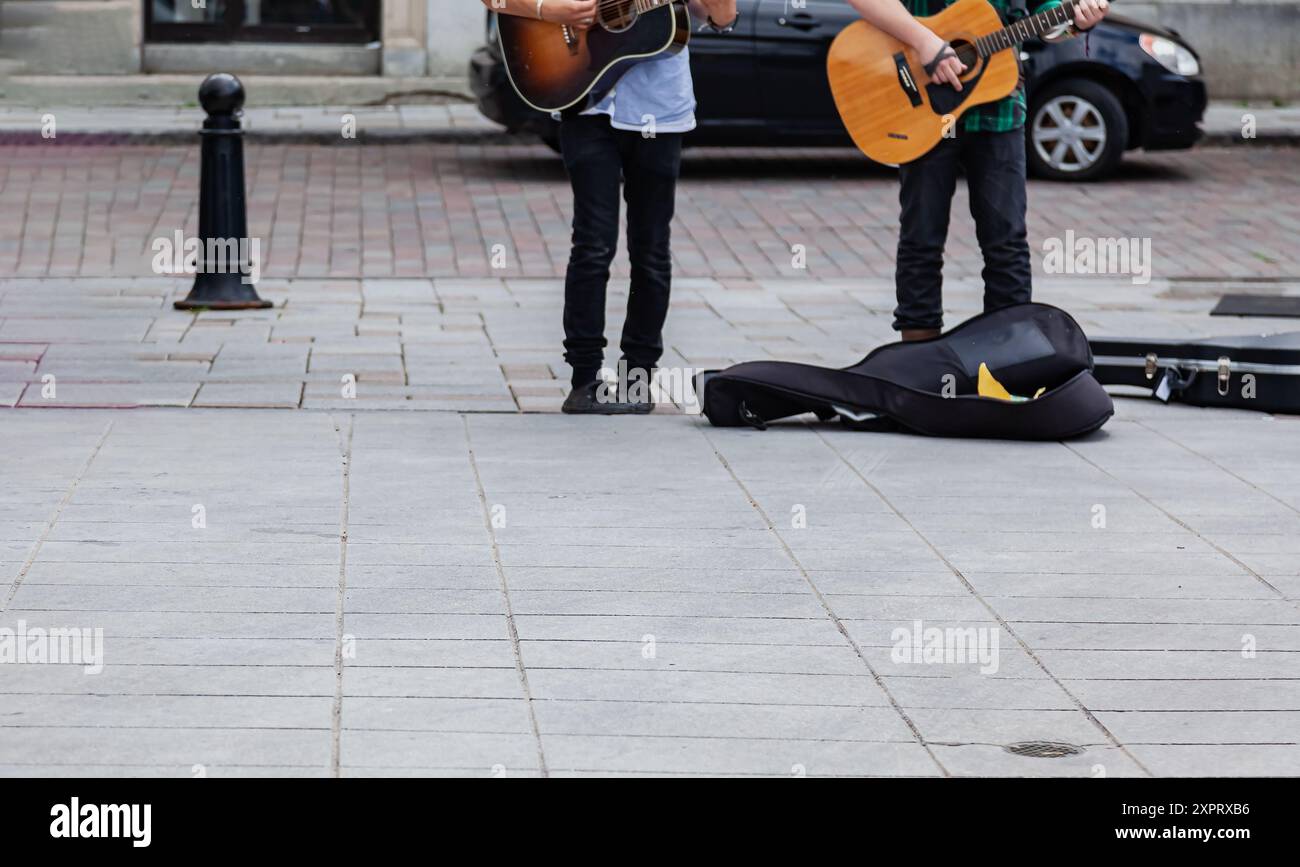 Kingston, Ontario, Canada, 17AUG 2014 - vue de musiciens masculins de rue de la taille vers le bas tapant leurs guitares sur le trottoir Banque D'Images