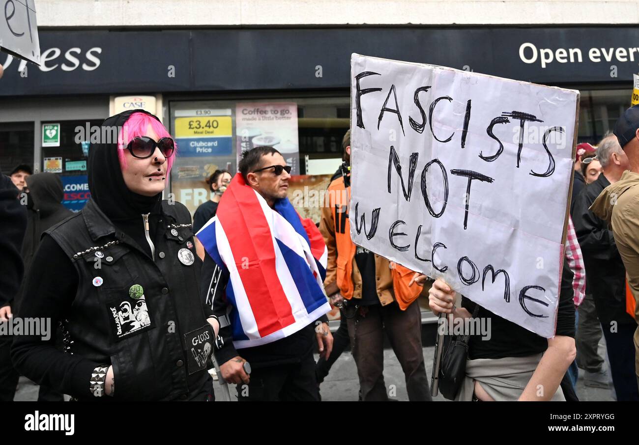 Brighton UK 7 août 2024 - homme portant un drapeau syndical parmi les groupes antifascistes protestant contre leur présence dans la ville ce soir . Il y a eu des émeutes raciales depuis le meurtre de 3 enfants à Southport en juillet : Credit Simon Dack / Alamy Live News Banque D'Images