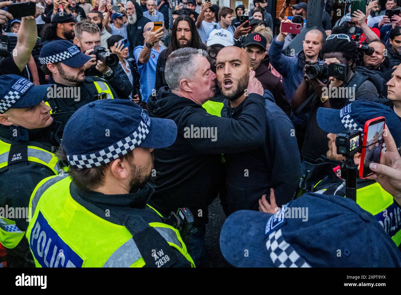 Londres, Royaume-Uni. 7 août 2024. Un homme se met en colère contre la manifestation disant que c'est son pays et montrant un tatouage de trois lions sur son ventre, il est finalement emmené par la police - Un Stop Racism, arrêtez la haine et arrêtez la manifestation d'extrême droite - Une réponse aux manifestations d'extrême droite attendues dans ou autour des centres d'asile et d'immigration, dans ce cas à Immigration and Nationality services Ltd North Finchley. Organisé par HOPE Not Hate et résistez au racisme. Crédit : Guy Bell/Alamy Live News Banque D'Images