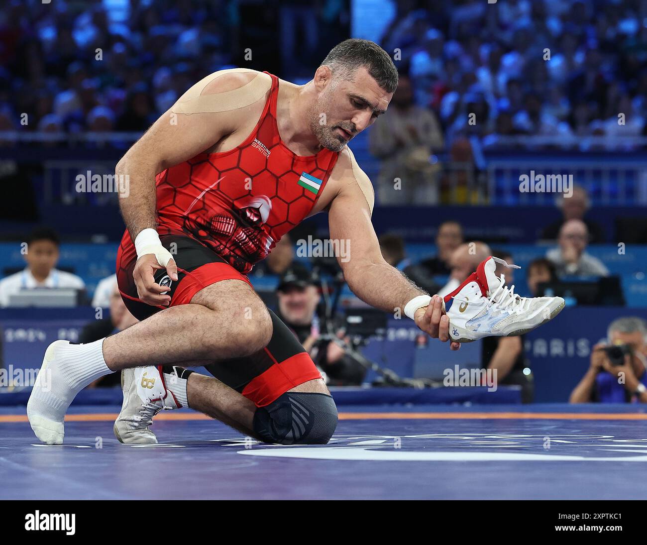 Paris, France. 7 août 2024. Rustam Assakalov d'Ouzbékistan laisse ses chaussures à l'arène comme signe de sa retraite après avoir été battu par Gabriel Alejandro Rosillo Kindelan de Cuba lors du match pour la médaille de bronze gréco-romaine masculine de 97 kg aux Jeux Olympiques de Paris 2024 à Paris, France, le 7 août 2024. Crédit : Zhang Fan/Xinhua/Alamy Live News Banque D'Images