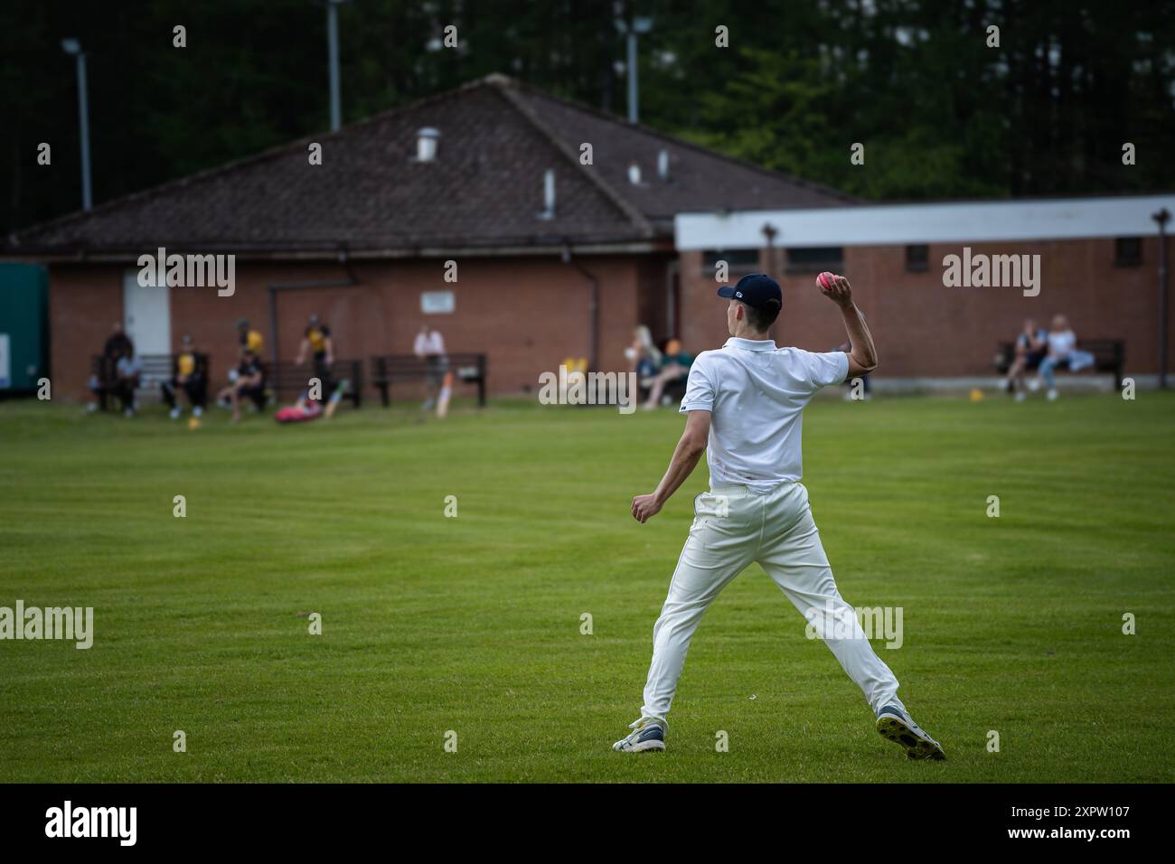 Fielder lançant la balle dans une partie de cricket Banque D'Images