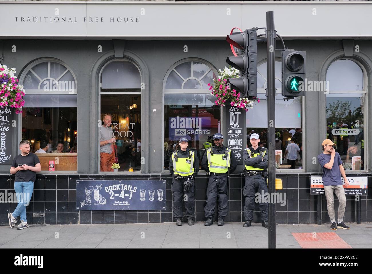 Londres, Royaume-Uni, 7 août 2024. Des policiers surveillent la situation à Walthamstow. Les magasins et autres commerces ferment tôt avant une éventuelle manifestation d'extrême droite contre l'immigration et une contre-manifestation antiraciste prévue. Une liste de 39 bureaux de soutien à l'immigration et d'avocats a été diffusée sur les médias sociaux pour encourager les manifestations aux adresses fournies. Crédit : onzième heure photographie/Alamy Live News Banque D'Images