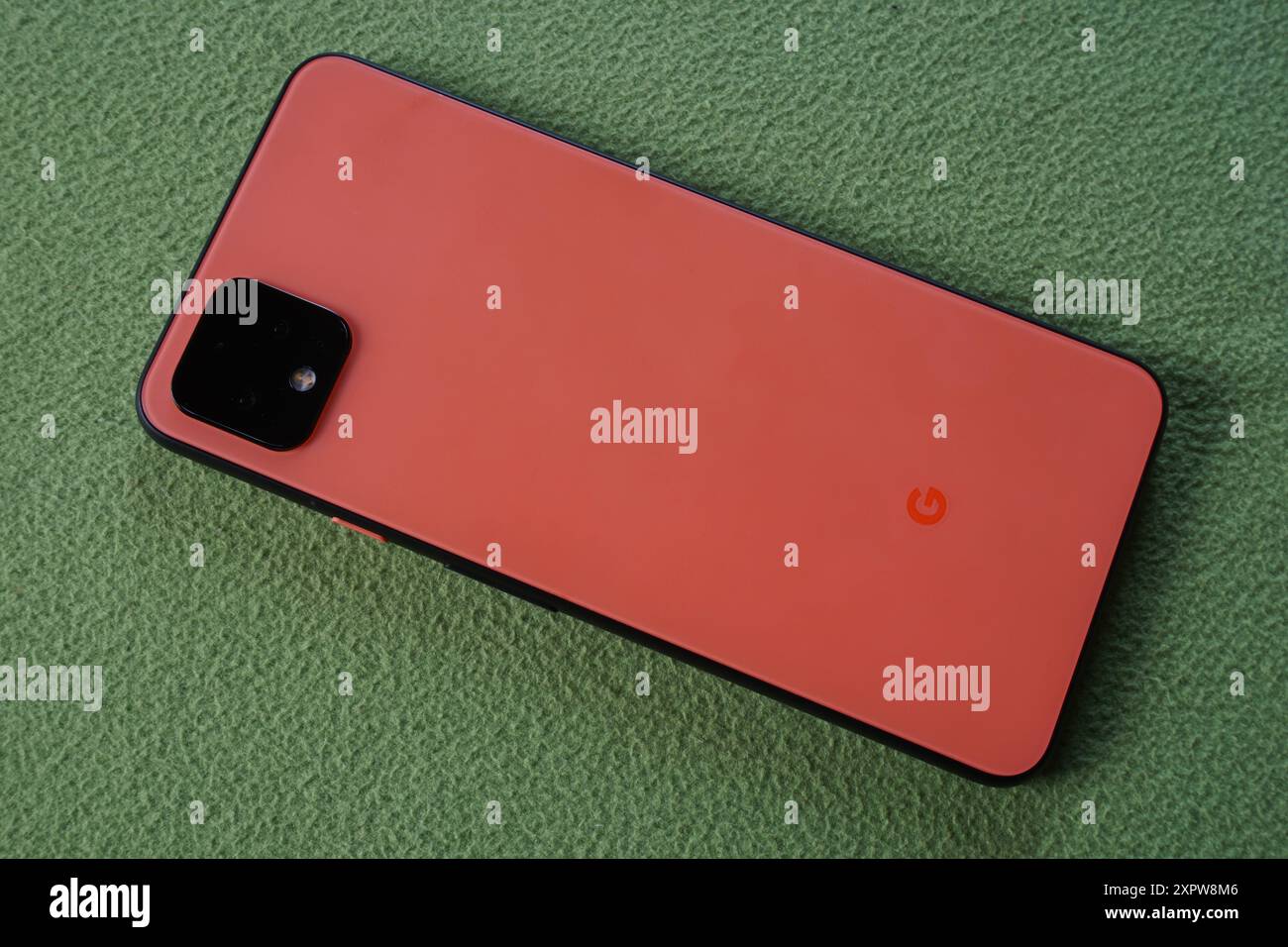 Terengganu, Malaisie - 23 août 2024 : gros plan du smartphone google pixel 4 orange sur fond vert Banque D'Images