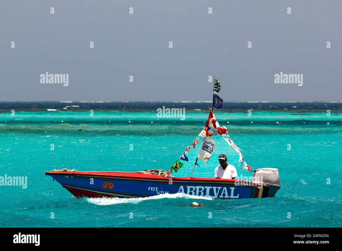 Cruising Along - Water Taxi / Vendor SlowlyMotoring à travers une Caraïbe Turquoise à la réserve naturelle marine de Baradal, les Grenadines, Caraïbes orientales Banque D'Images