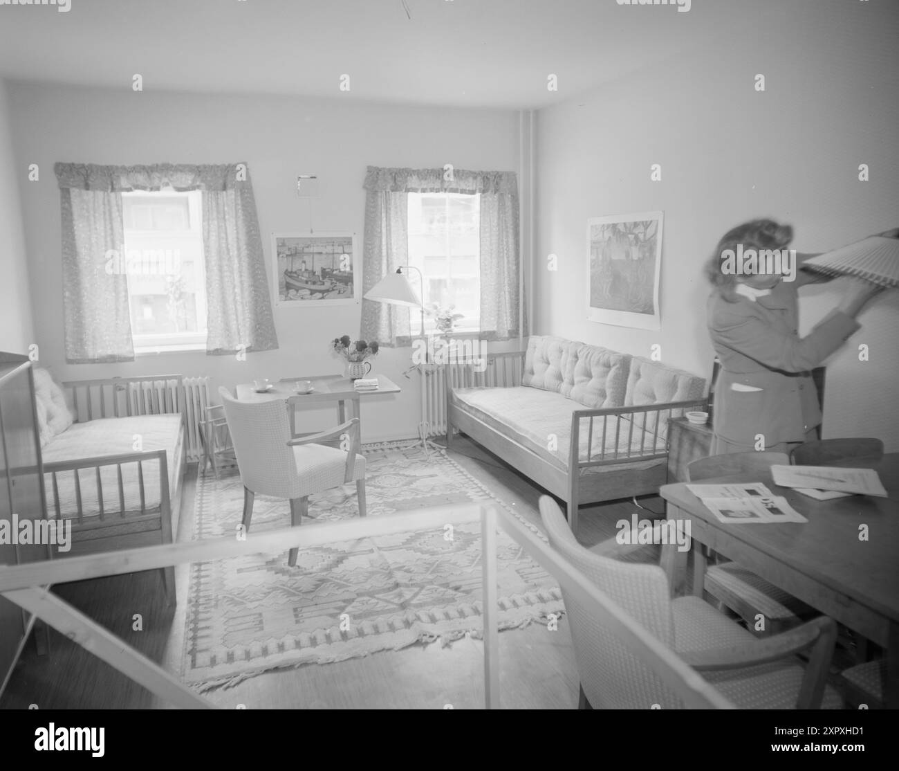 Current 1948 : nous apprenons à vivre en propriété L'exposition 'Live Right' comme le 'Selskapet for Oslo byes Well' récemment organisé, montre qu'il est possible pour une grande famille d'exploiter l'espace dans un petit appartement sans avoir besoin de paraître surpeuplé. -Le salon dans un appartement de 2 pièces avec 5 membres de la famille. Les trois enfants ont la chambre à coucher, et les parents ont mis leurs lits dans le salon, pourvu pour eux de coussins de dossier, de sorte qu'il devienne un coin canapé agréable pendant la journée. Agréable et pratique. Photo ; NTB / courant ***PHOTO NON TRAITÉE*** Banque D'Images