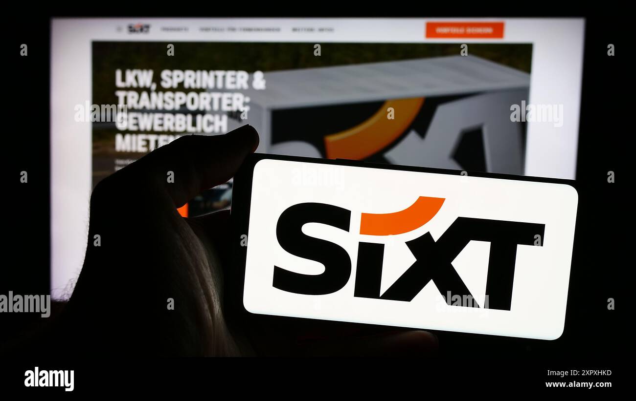Personne tenant un smartphone avec le logo de la société de location de voitures allemande Sixt se en face du site Web. Concentrez-vous sur l'affichage du téléphone. Banque D'Images