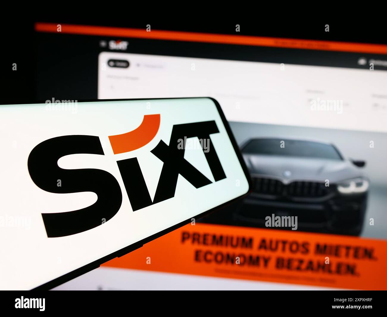 Smartphone avec logo de la société de location de voitures allemande Sixt se en face du site Web de l'entreprise. Mettez l'accent sur le centre-gauche de l'écran du téléphone. Banque D'Images