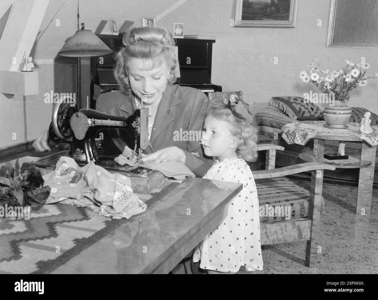Current 1948 : femmes qui dirigent des doubles livesfemmes qui travaillent à double emploi. Elles participent à la vie professionnelle et sont aussi des ménagères. Pour la danseuse Mme Ellen Sæther, le ménage n’est pas non plus un lit de roses. Elle s'entraîne pendant quelques heures chaque matin et se produit le soir. Comme la plupart des autres ménagères, elle passe le reste de la journée debout dans les files d'attente, lavant les planchers et cuisinant. La fille de trois ans est maintenant avec une tante du parc, mais quand elle était plus petite, des tantes ou des grands-mères aimables ont été mobilisées comme nounous. Son mari est une bonne "aide pour les enfants" s'il n'a pas la soirée occupée avec & pla Banque D'Images