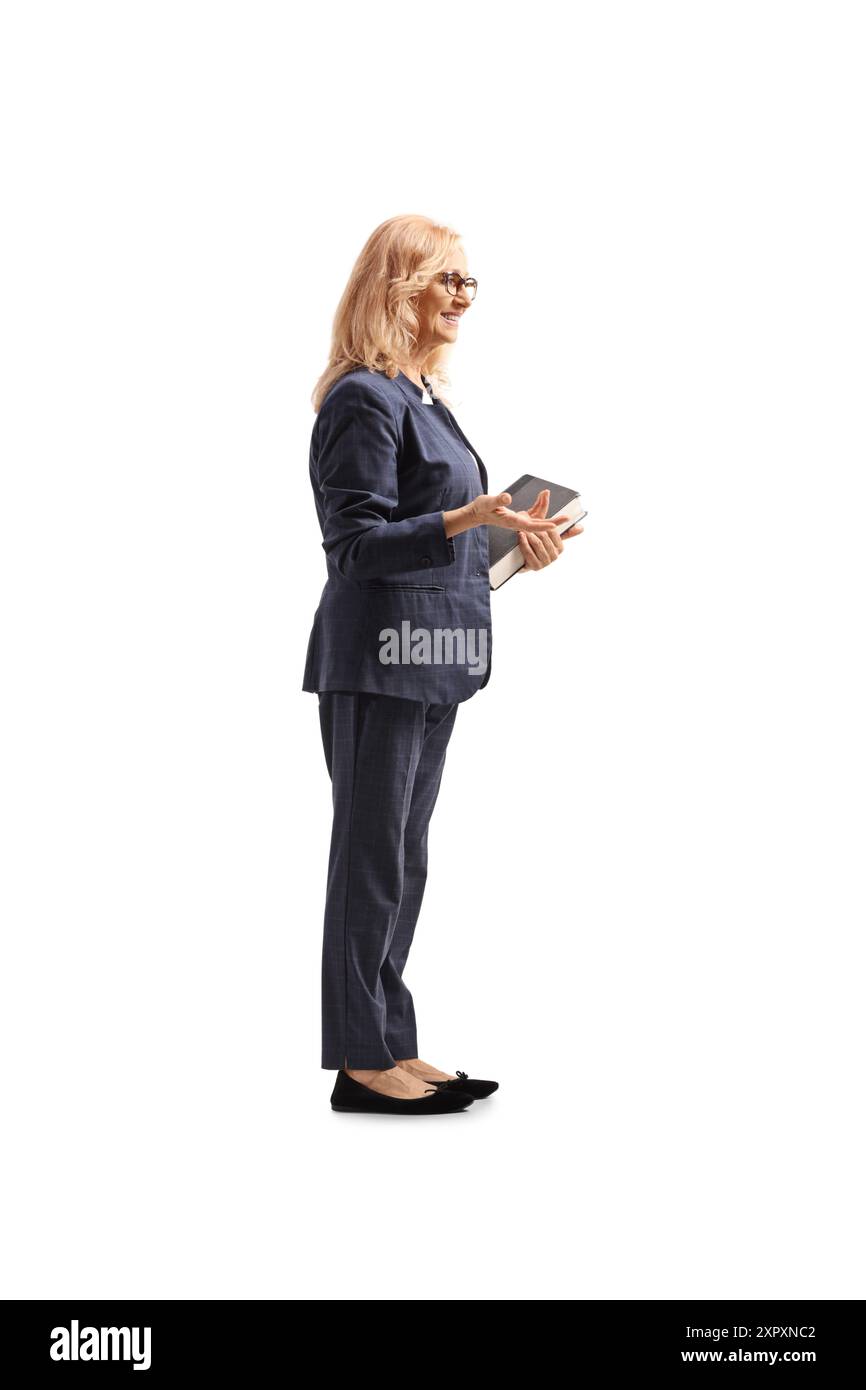 Plan de profil pleine longueur d'une enseignante tenant des livres et parlant isolé sur fond blanc Banque D'Images