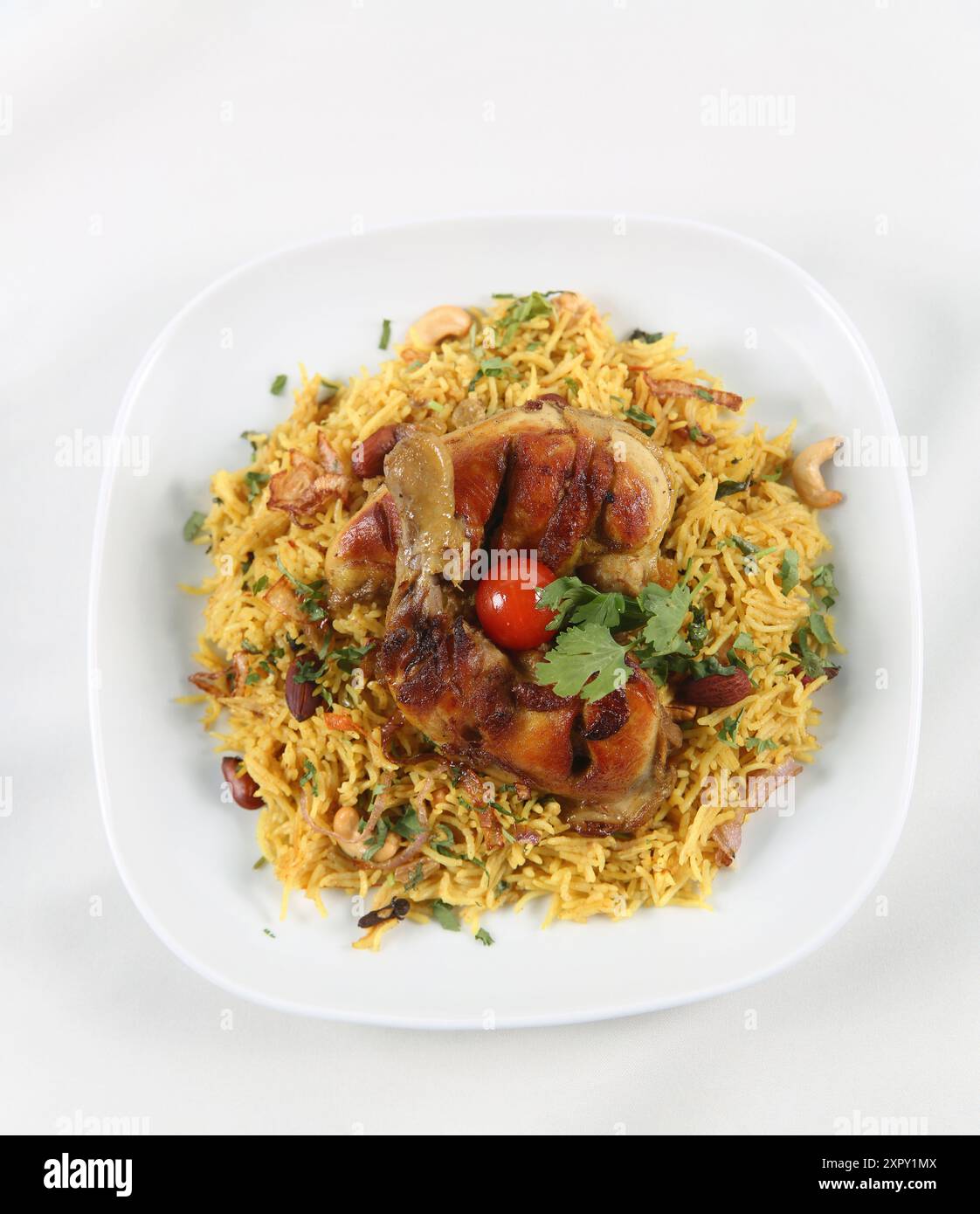 Cuisine arabe ; poulet 'Kabsa' ou poulet Biryani riz. Servi avec des oignons dorés frits, des noix grillées croustillantes et des raisins secs, du persil frais, Banque D'Images