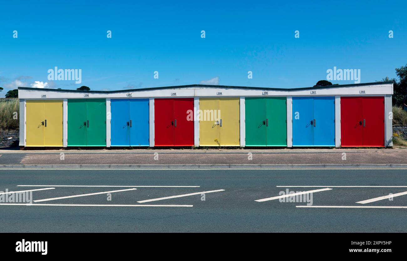 Une rangée de cabanes de plage colorées sur Queens Drive, Exmouth, Devon Banque D'Images