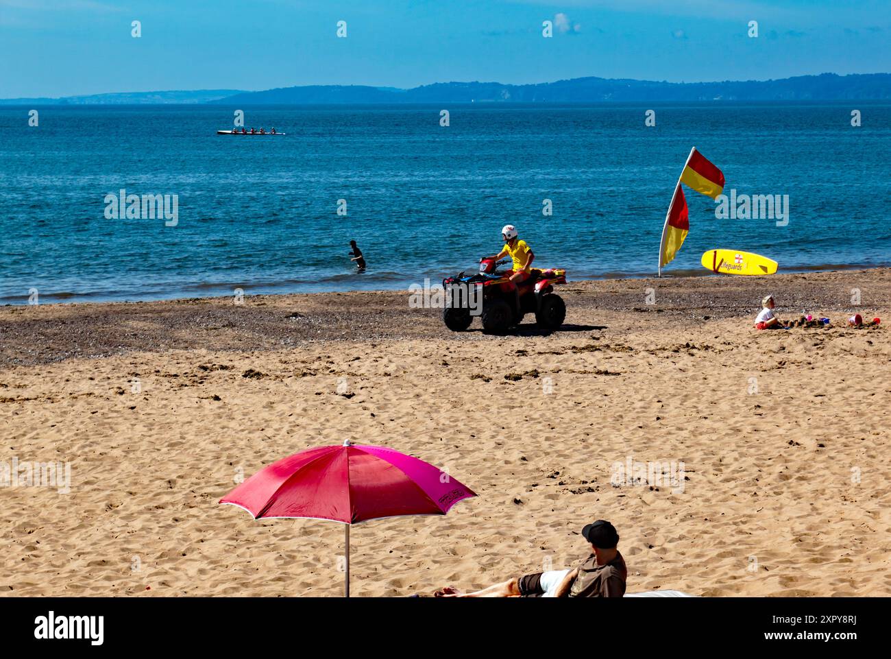 Sauveteur de la RNLI patrouillant la plage sur un Quadbike, à Exmouth, Devon Banque D'Images