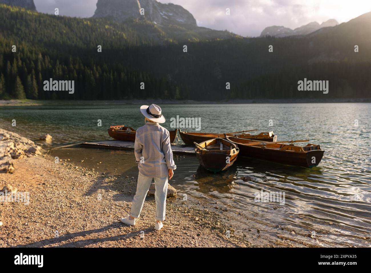 Une femme portant un chapeau regarde les bateaux près du lac Noir à Durmitor Banque D'Images