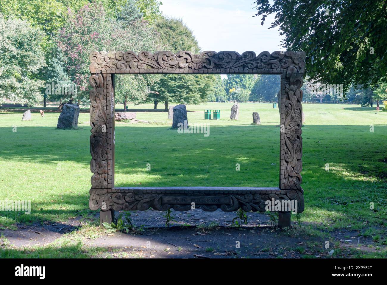 Les pierres Gorsedd et les poubelles photographiées à travers le cadre photo géant en bois à Bute Park, Cardiff, Royaume-Uni. Banque D'Images