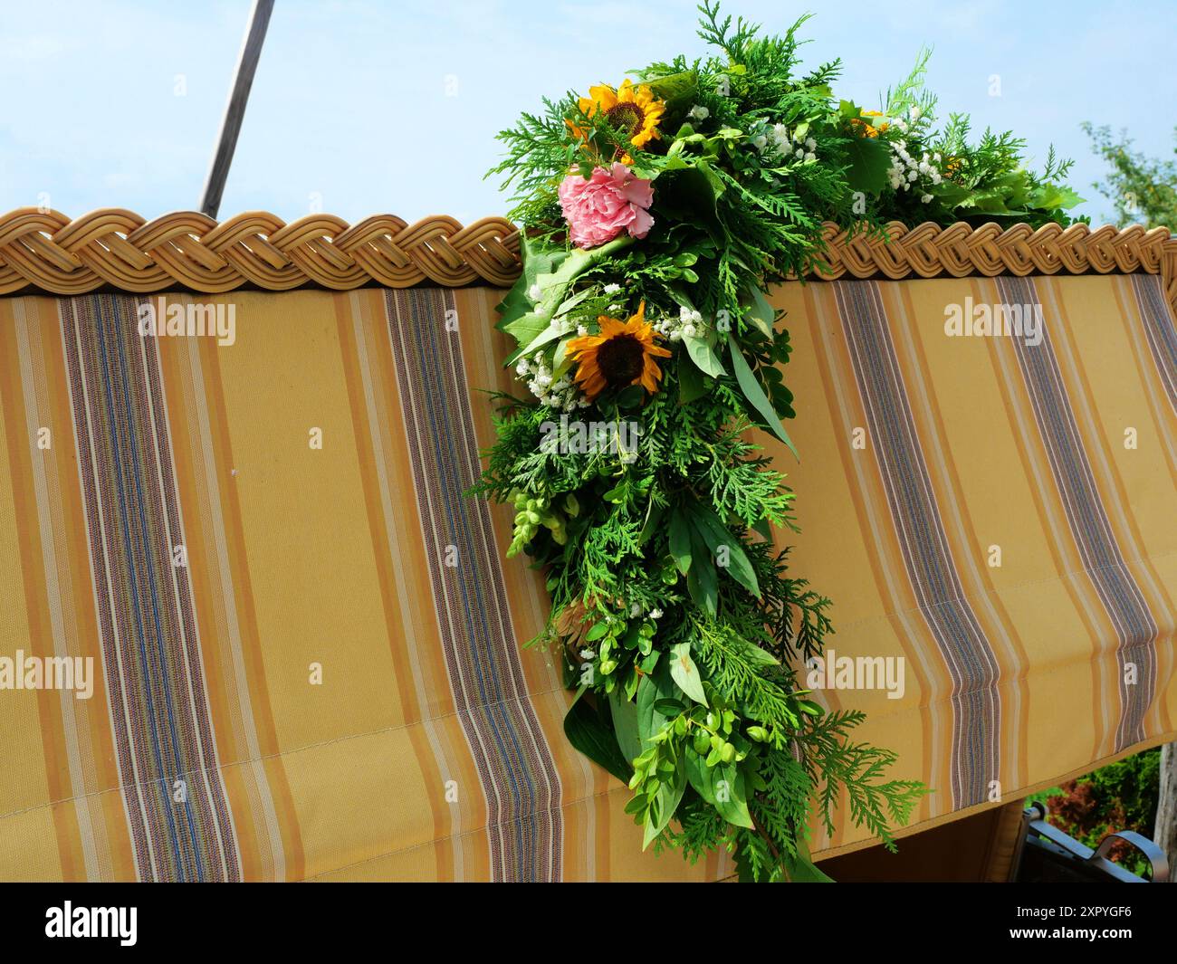 Couronne de fleurs avec fleurs d'été sur une chaise de plage, parfait pour les cartes et les voeux d'été. Un cadeau charmant pour une célébration estivale. Banque D'Images