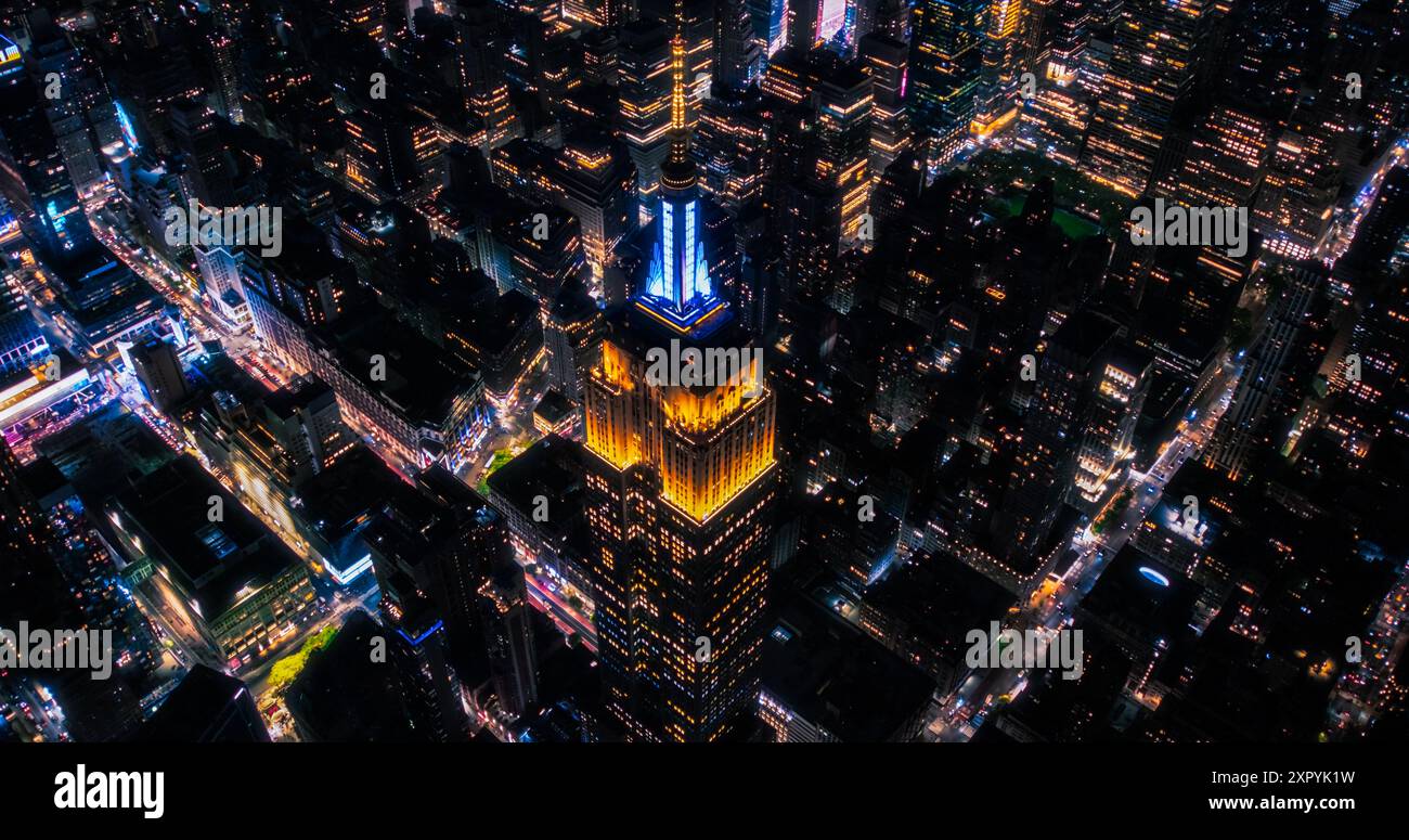 New York City Business Center vu du haut. Photo aérienne d'un célèbre gratte-ciel Art déco la nuit. Vue en hélicoptère sur un impressionnant site touristique. Panorama de Manhattan avec Empire State Building Banque D'Images