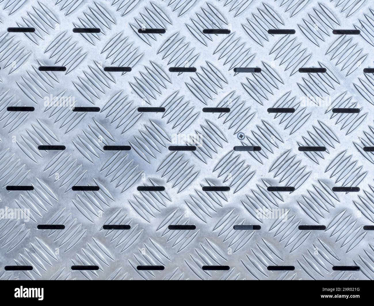 Fond abstrait, texture de l'escalier de bâtiment industriel en plaques de métal antidérapantes en acier inoxydable, mise au point sélective Banque D'Images