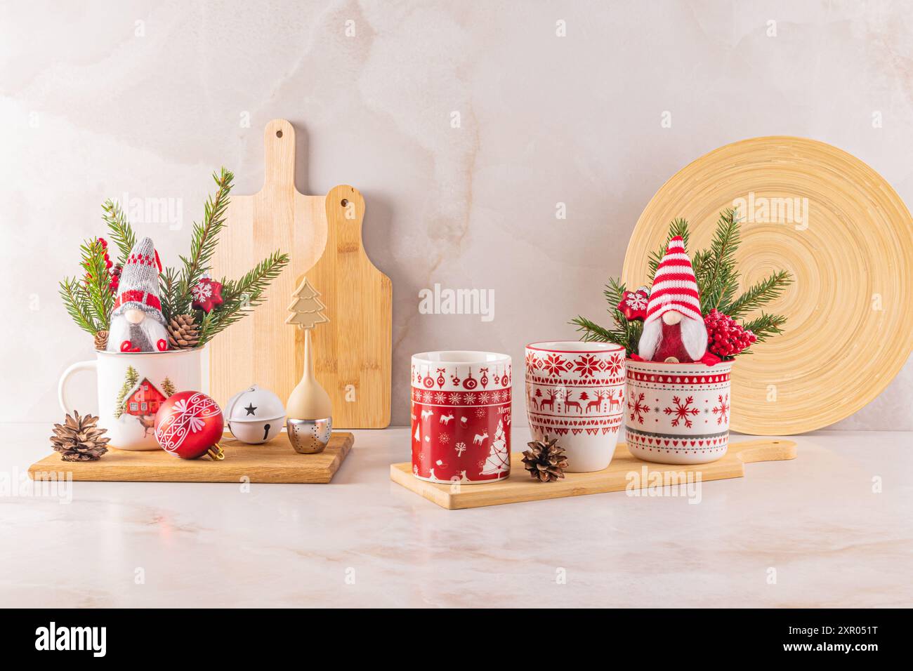 Deux tasses en céramique blanche élégantes avec un ornement de Noël rouge dans une composition festive de décorations pour la maison pour les vacances. Vue de face. Banque D'Images