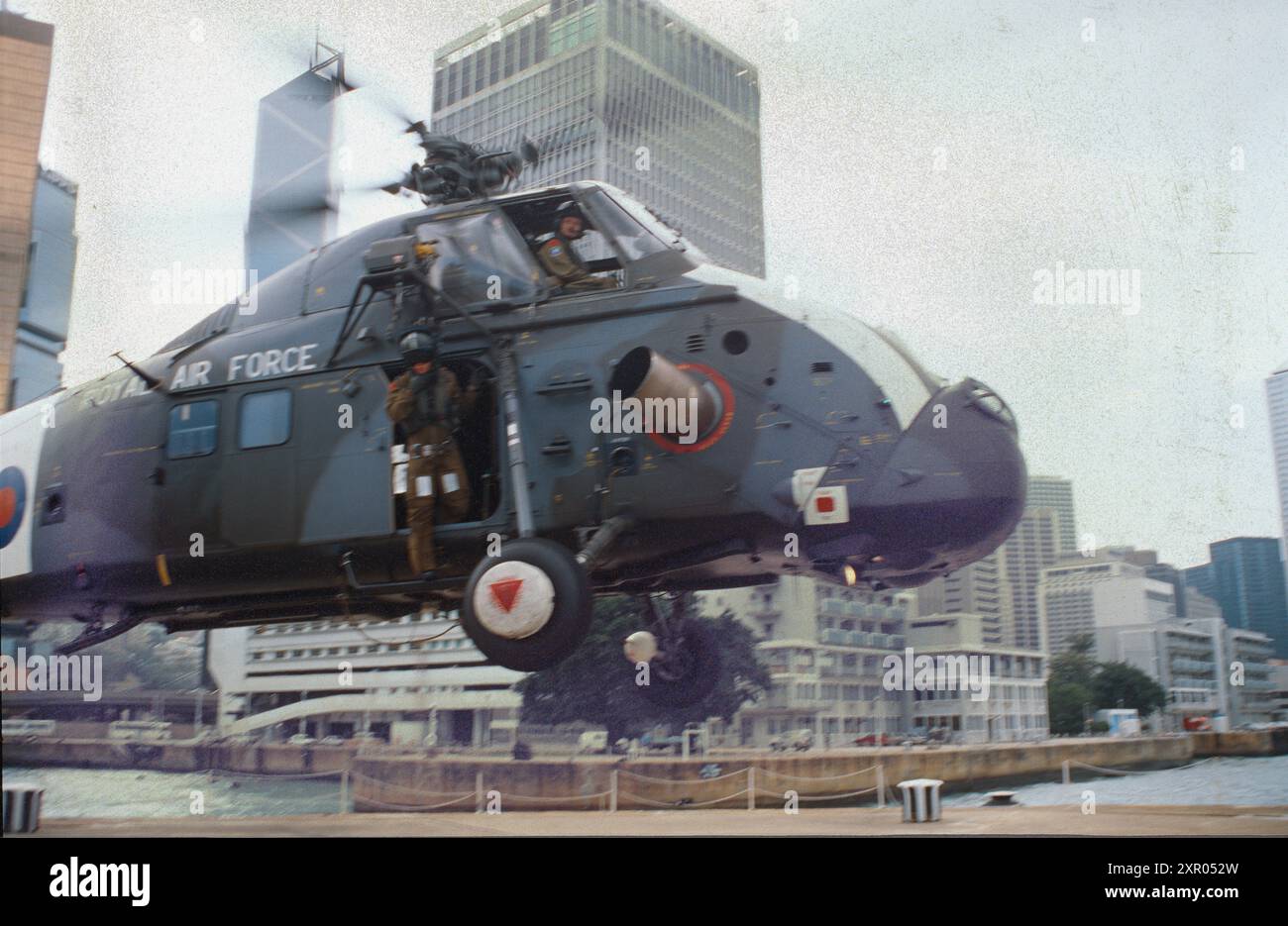 Hélicoptère Wessex HC Mk2 du No 28 (AC) Squadron, RAF SEK Kong, atterrissant sur l'héliport du HMS Tamar, Hong Kong, date 1996. À l'arrière-plan se trouve le Prince of Wales Building, QG British Forces Hong Kong, maintenant QG de l'Armée populaire de libération à Hong Kong Banque D'Images