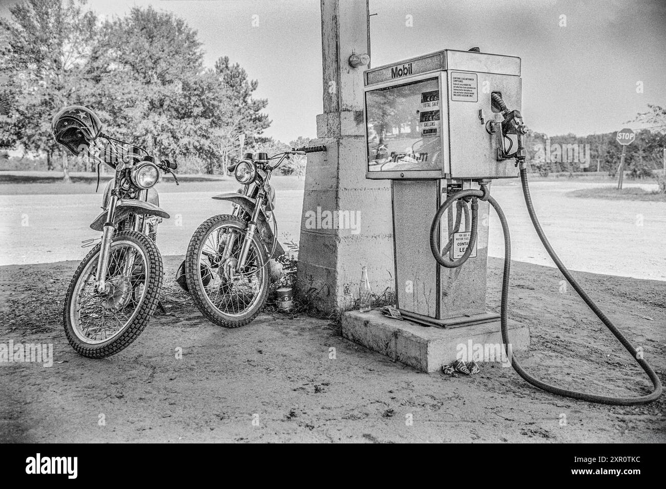 Macédoine, Arkansas, États-Unis – 23 juin 2024 : photo horizontale de deux vélos tout-terrain vintage à côté d’une ancienne pompe à essence Mobil en 1975. Banque D'Images