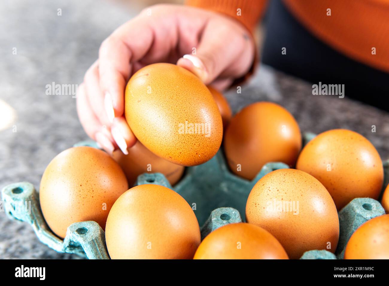 gros plan d'une main prenant un œuf pour une recette Banque D'Images