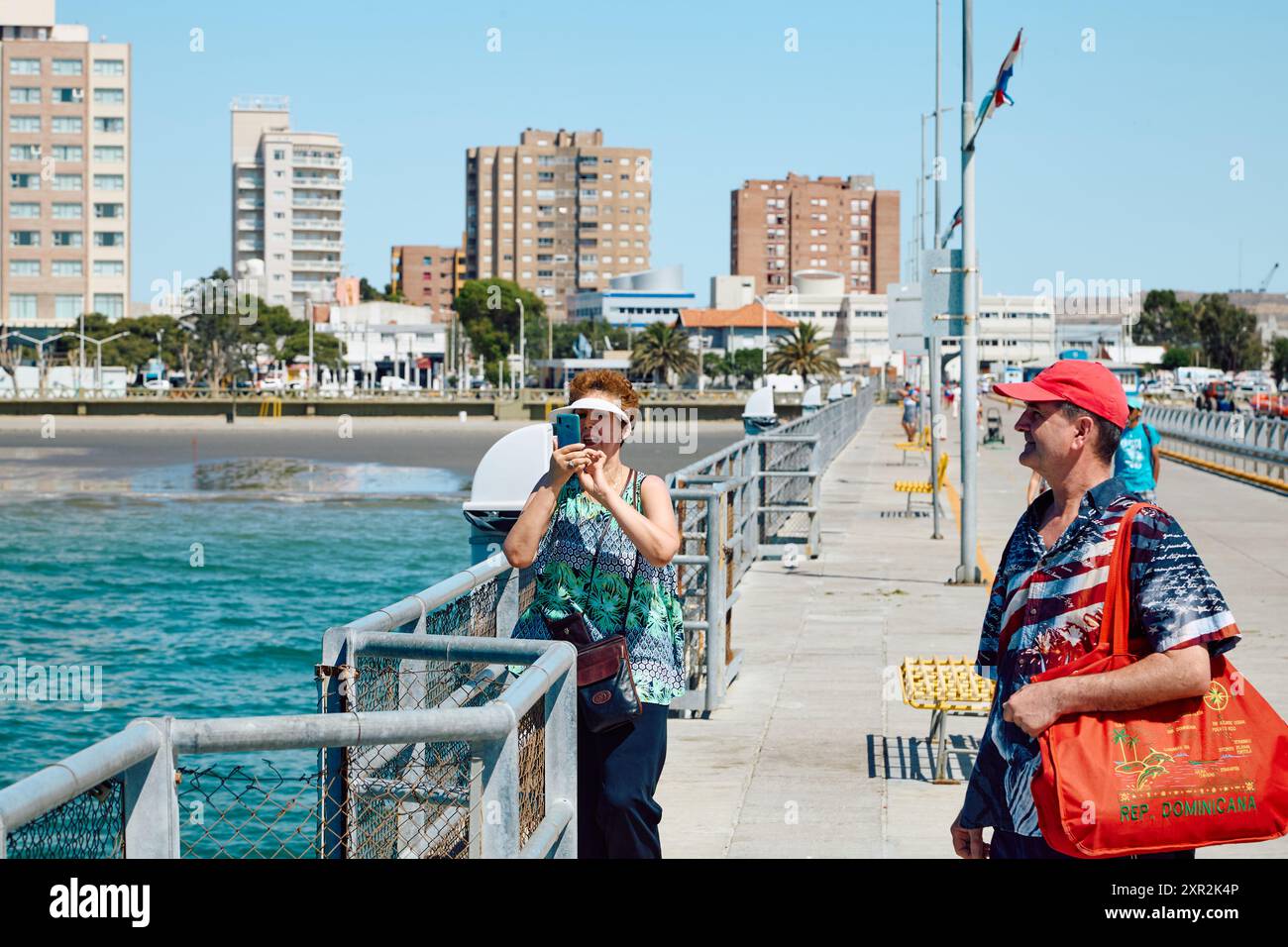 Deux touristes homme et femme sur une belle journée ensoleillée sur la jetée. Côte Atlantique, ville de Puerto Madryn Banque D'Images