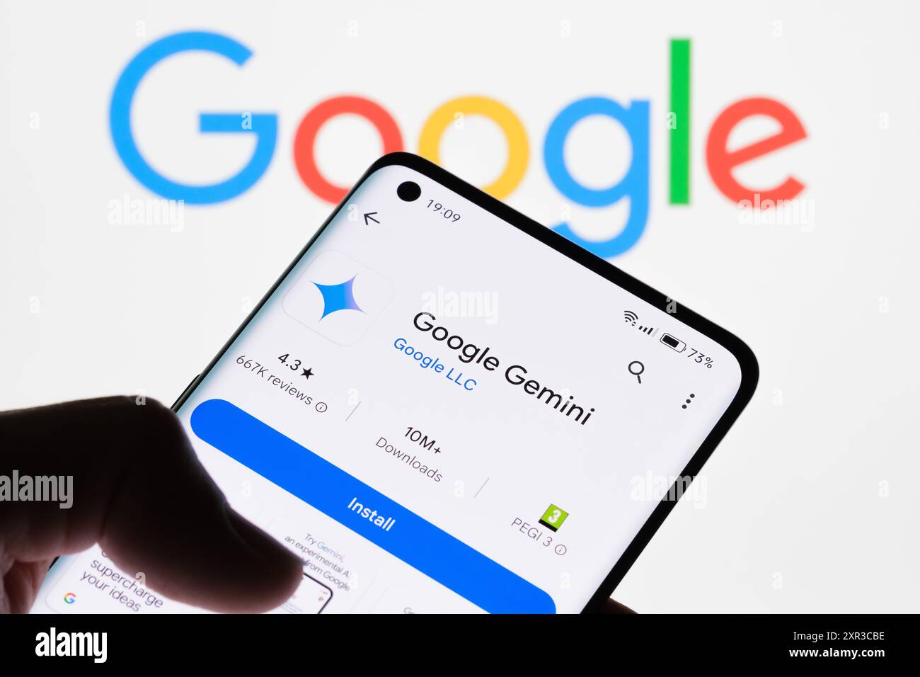 Gros plan de l'écran d'un smartphone affichant l'application Google Gemini avec le logo Google en arrière-plan, illustrant le lien entre Google Gemini et Googl Banque D'Images