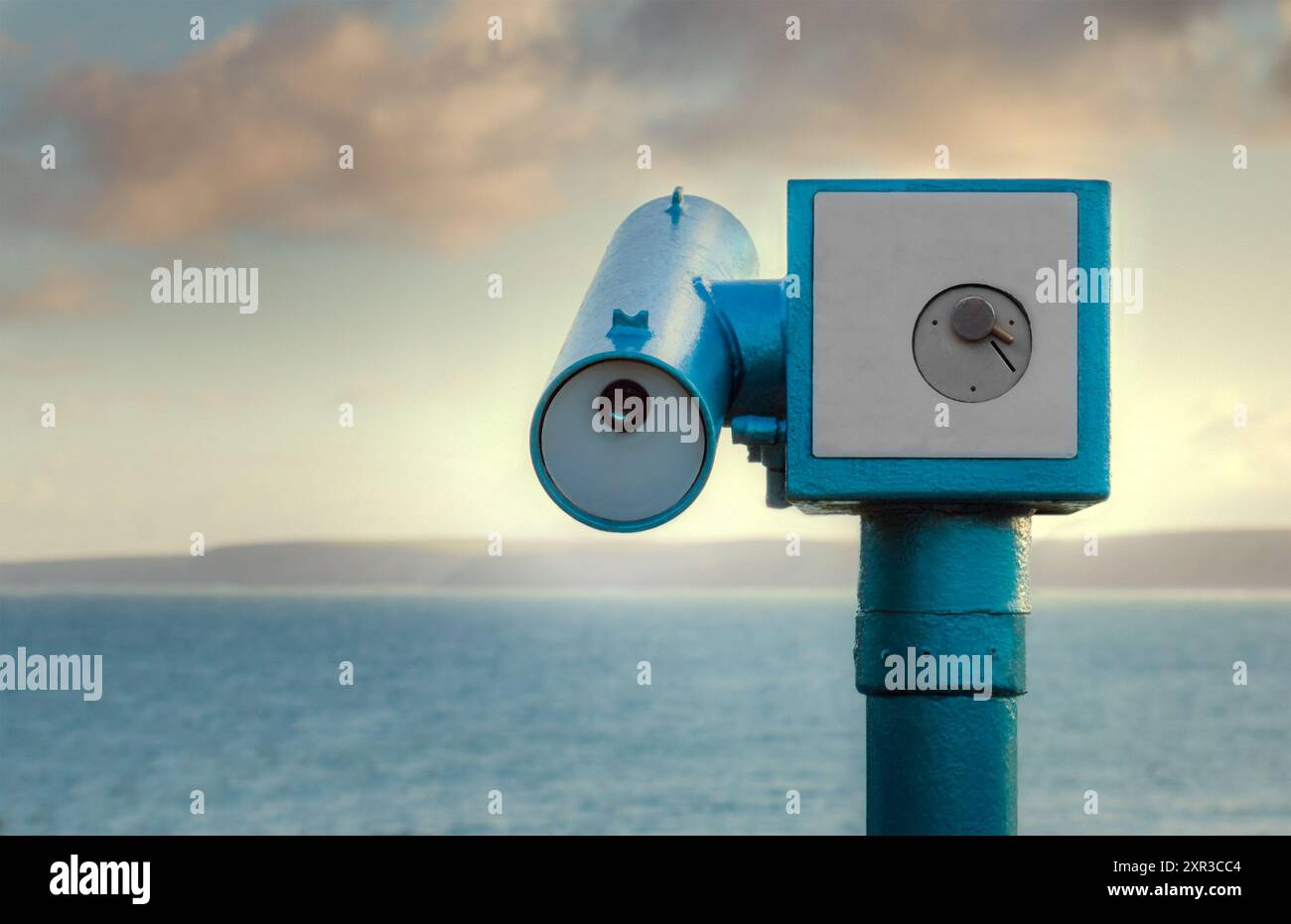 Télescope - bleu, télescope à pièces regardant vers la mer avec des falaises à l'horizon. Les machines sont un accessoire typique des hotspots touristiques. Banque D'Images
