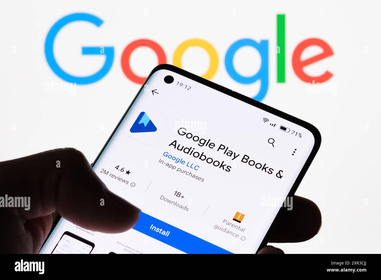 Gros plan de l'écran d'un smartphone affichant l'application Google Play livres et livres audio avec le logo Google en arrière-plan, illustrant la connexion entre Banque D'Images