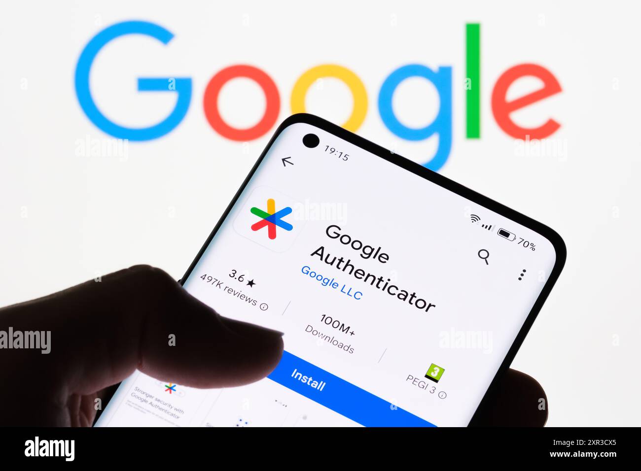 Gros plan de l'écran d'un smartphone affichant l'application Google Authenticator avec le logo Google en arrière-plan, illustrant la connexion entre Google aut Banque D'Images